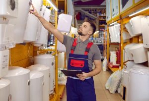 sales man checking traditional and tankless water heater