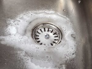 a person cleaning the drains