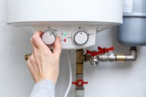 person adjusting the water heater thermostat Oceanside, CA