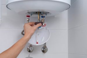 a plumber flushing the water heater