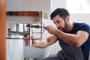 plumber repairing a leaky or damaged pipe