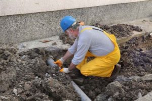 plumber repairing a damaged sewer line