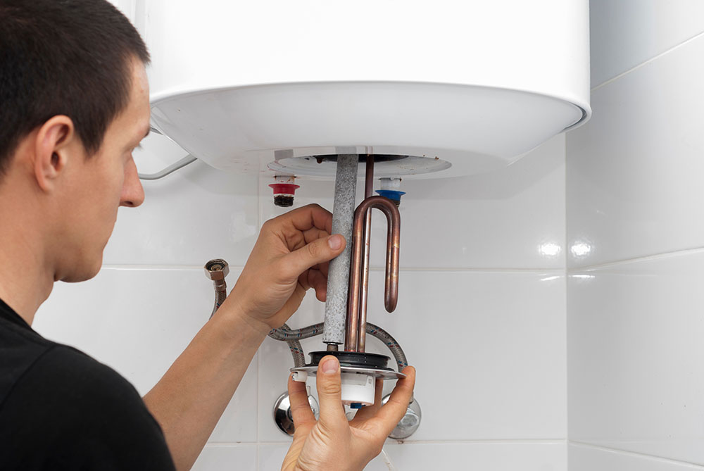 technician inspecting a traditional water heater Temecula, CA