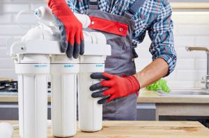 plumber installing a water filtration system